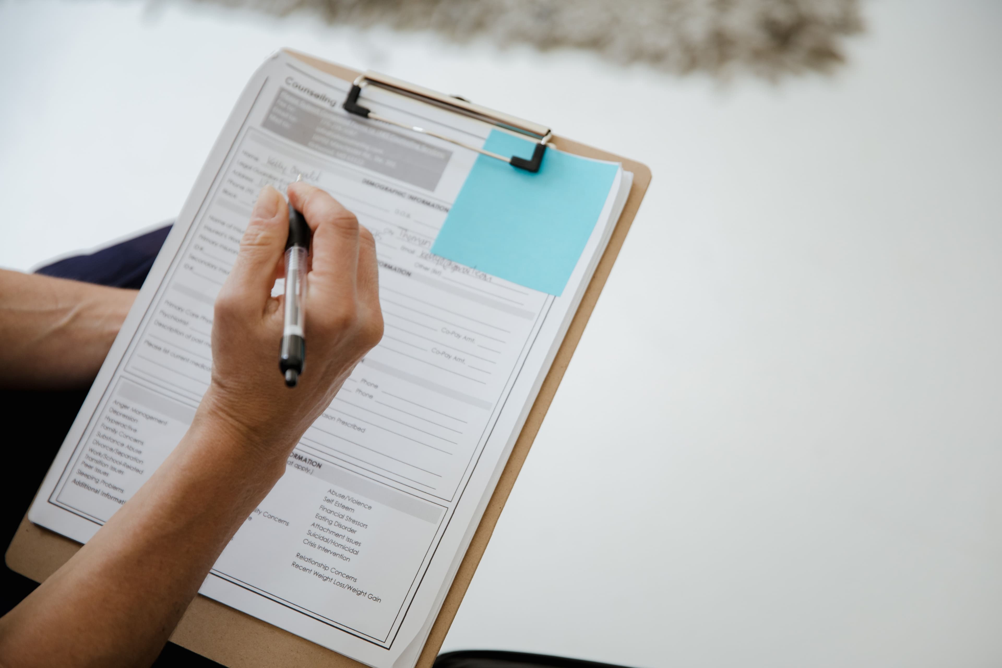 Professional completing and reviewing structured documentation on a clipboard