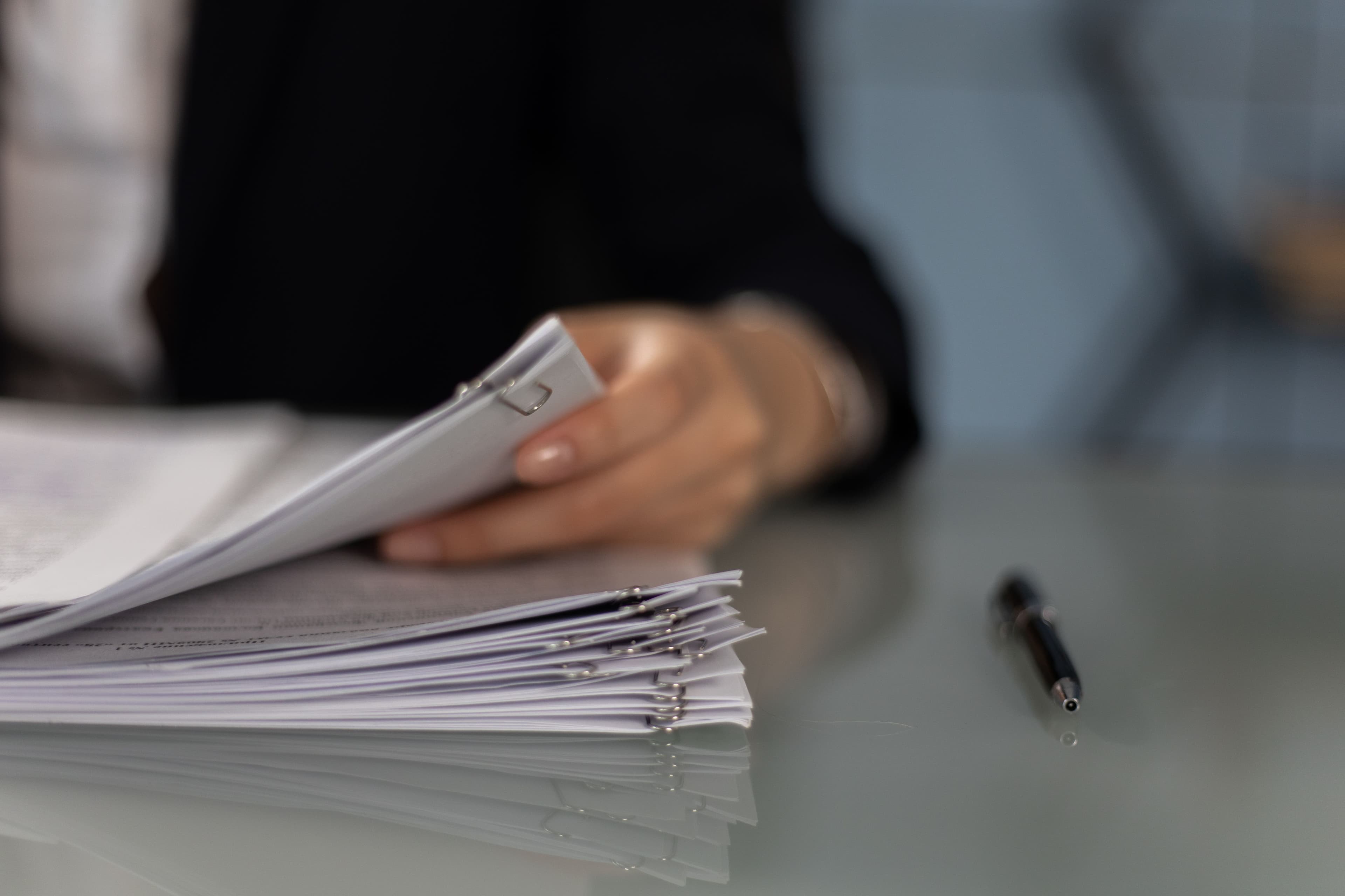 Professional reviewing procurement documents beside an organized stack of project materials