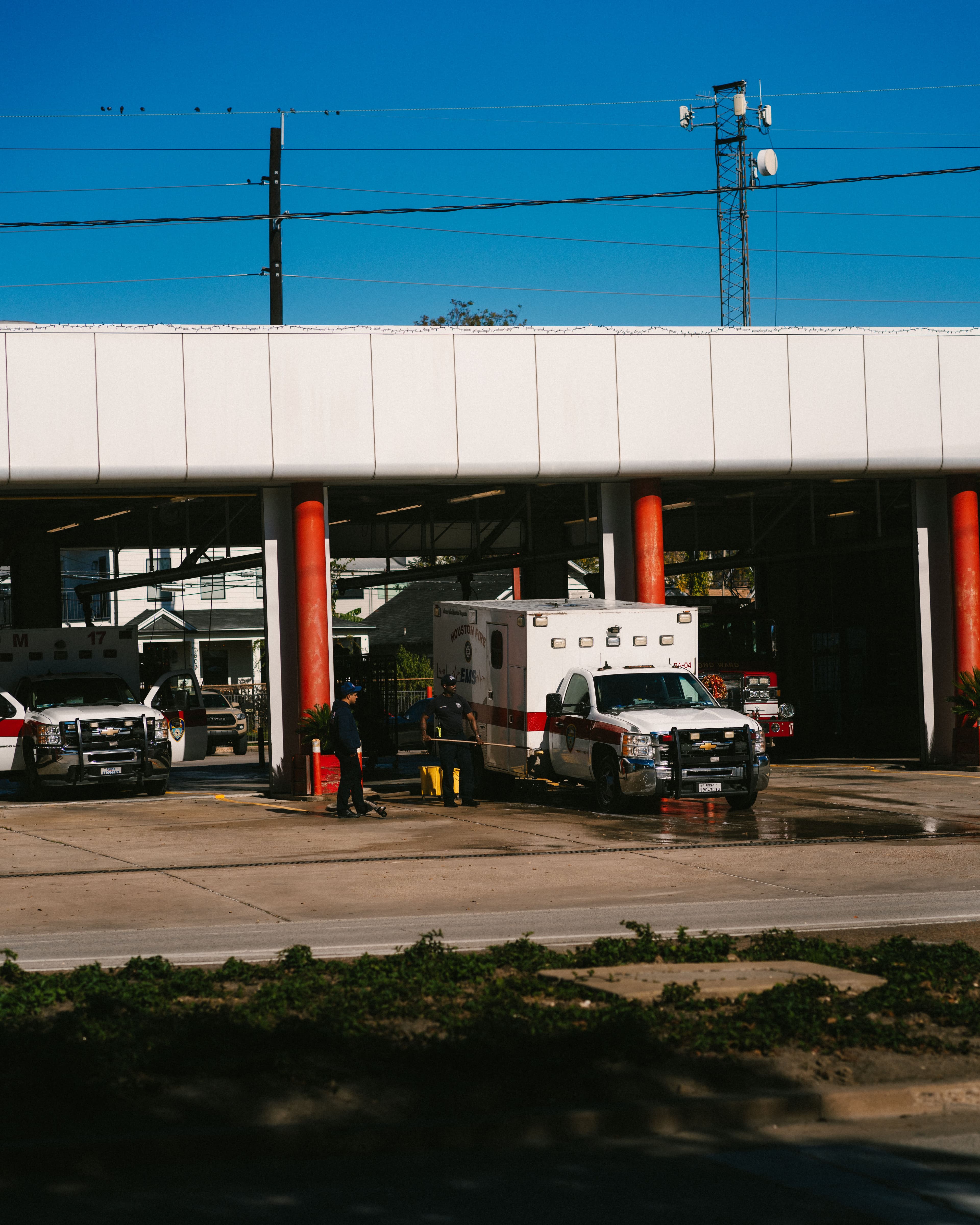 Fire and emergency medical services vehicles at a public safety facility beneath communications equipment